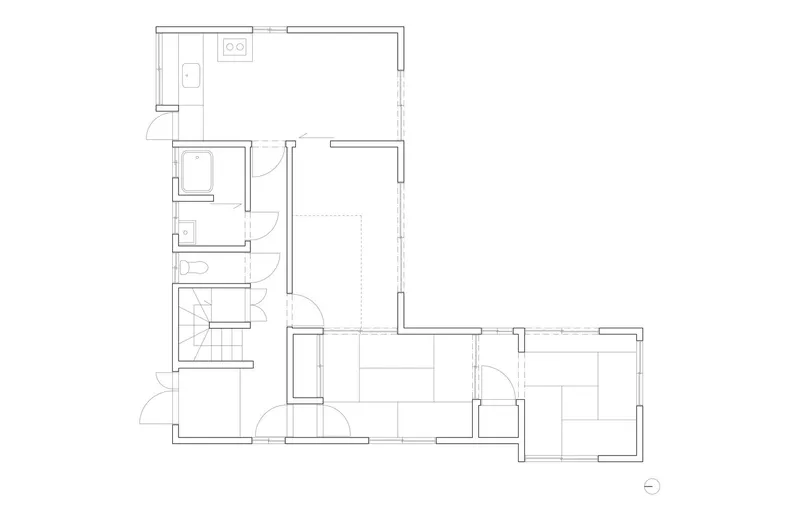 Floor plan drawing showing an L-shaped residence with kitchen, bathrooms, staircase and multiple rooms