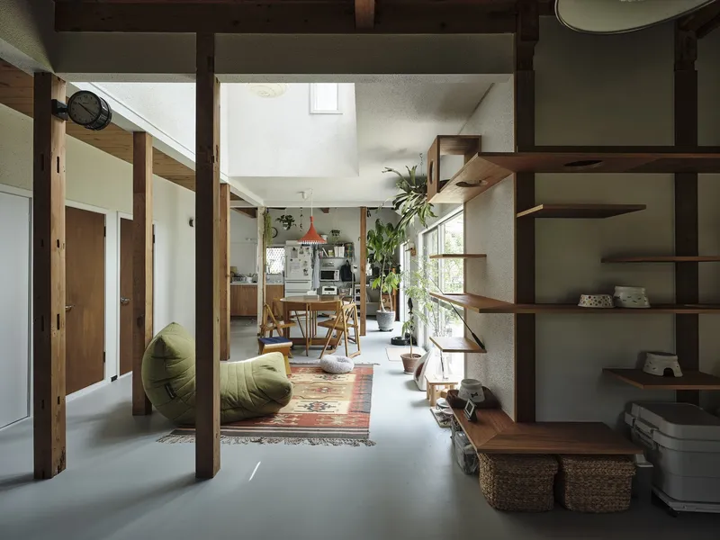 Open living space with exposed timber columns and shelving under a skylight