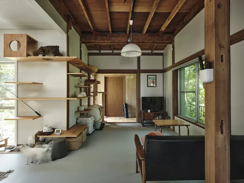 Living room with exposed timber beams and glass doors framing garden views