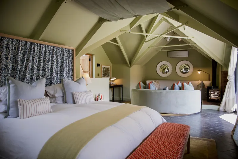 Guest suite with exposed painted trusses and a vaulted ceiling over a freestanding tub