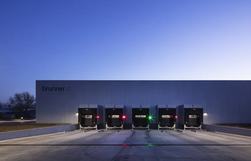 Five numbered loading dock bays with red and green indicator lights at twilight