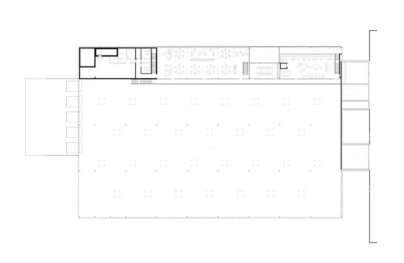 Floor plan drawing showing an open workshop hall with enclosed offices and support spaces along one edge
