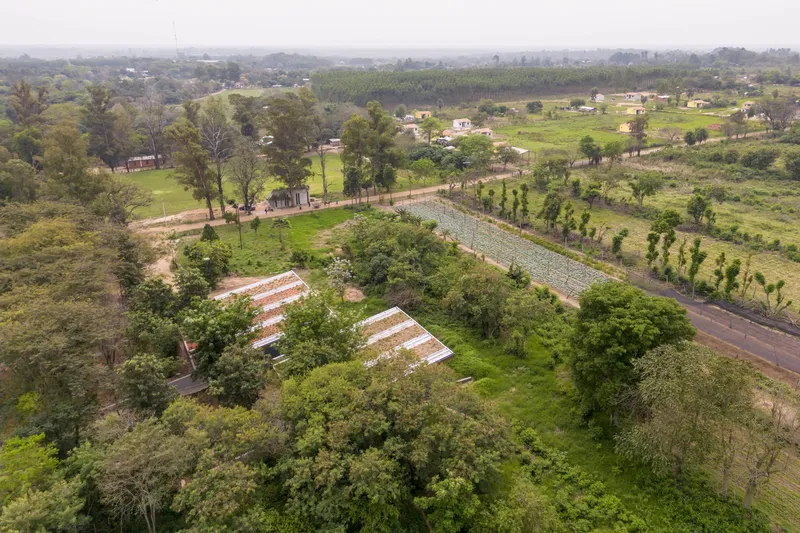 Aerial view of the rooftops half-hidden by surrounding trees in a rural patchwork landscape