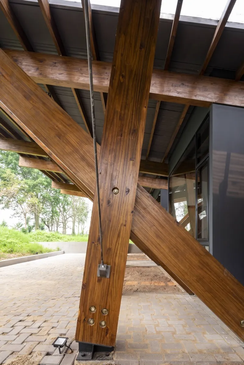 Junction of timber columns and diagonal braces with metal connectors and bolted steel plates