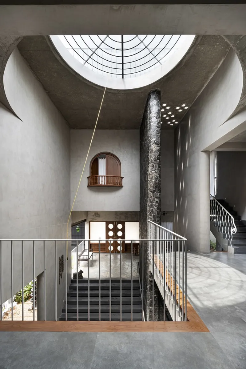 Upper level view showing the curved skylight and perforated metal stair railing