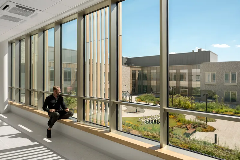 Interior window seat overlooking the courtyard garden with a person seated in afternoon sunlight