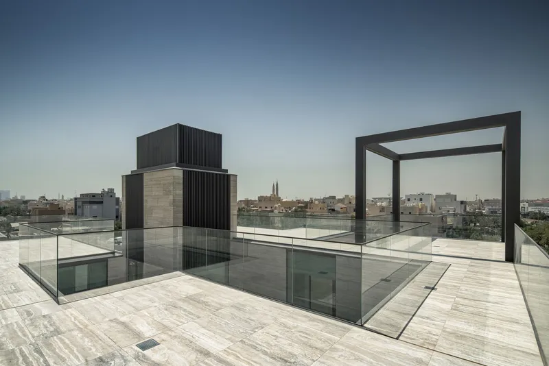 Rooftop terrace with glass floor skylights and a metal frame pavilion overlooking the cityscape