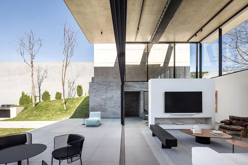 Open living area extending to terrace with bare trees and sloped lawn beyond