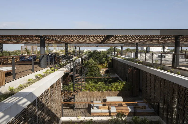 Rooftop courtyard with woven timber pergola, planted beds and timber deck seating areas below