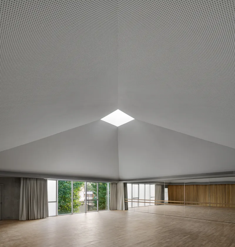 Dance studio with perforated acoustic ceiling, square skylight at the roof ridge and timber wall panels