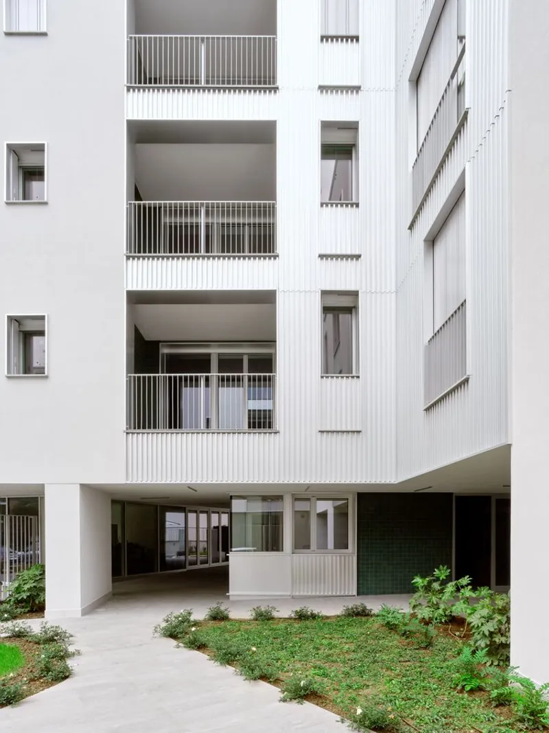 Interior courtyard view with tiered balconies and landscaped pathway between planted beds