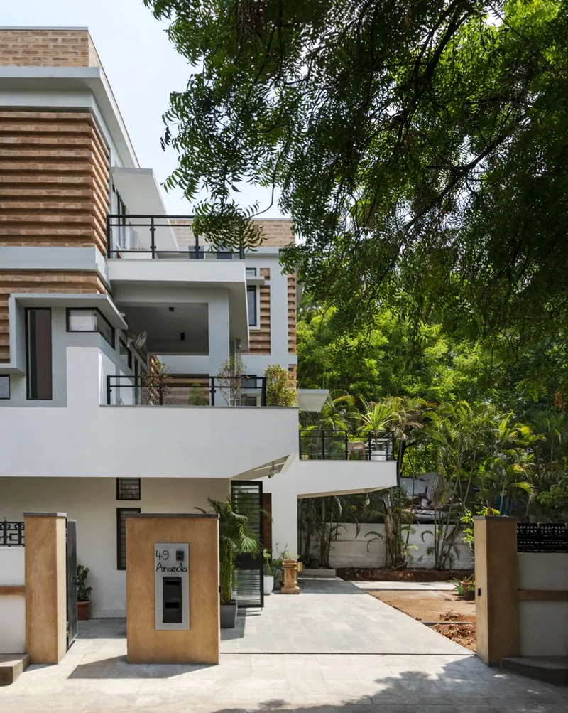 Stacked terraces with horizontal wood slat detailing framed by lush overhanging tree canopy