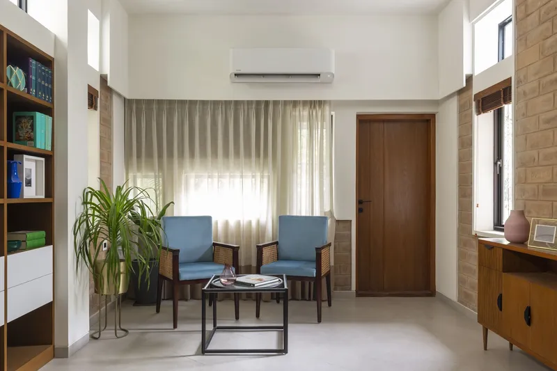Sitting area with two cane-back chairs and a planked brick accent wall in daylight