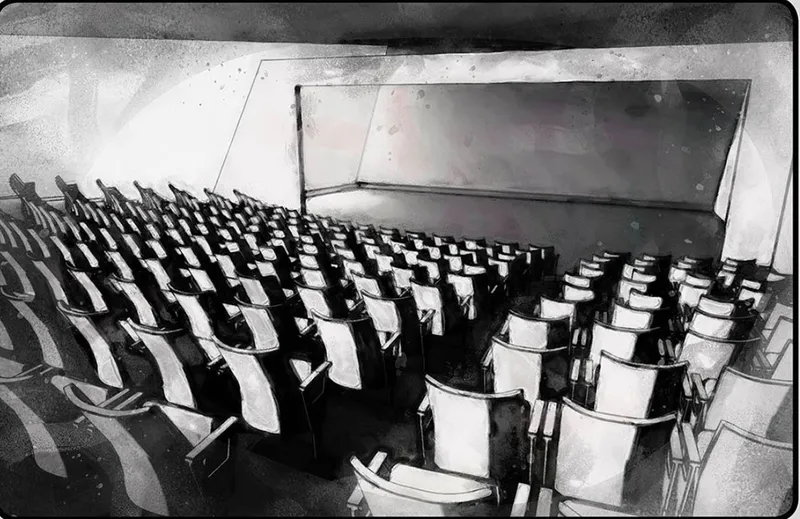 Rows of folding black and white chairs in a raked auditorium with angled concrete walls