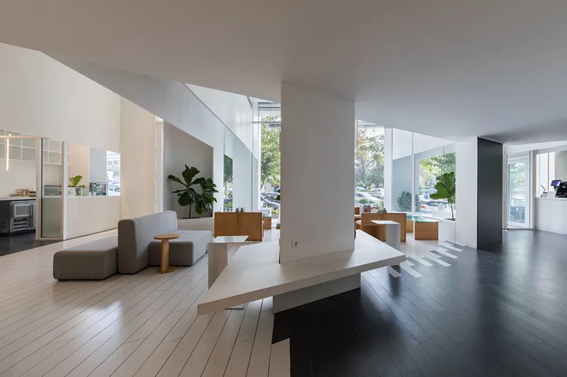 Open lobby space with white columns and contrasting black and white floor sections in daylight