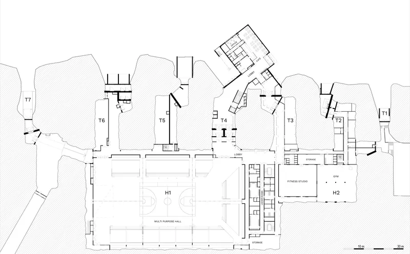 Floor plan drawing showing two large halls flanked by smaller building volumes and hatched landscape areas