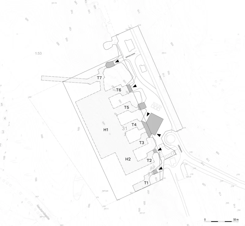 Site plan drawing showing multiple building footprints arranged along a diagonal access route with labeled zones