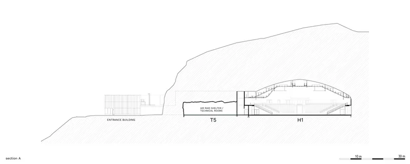 Section drawing showing a barrel-vaulted hall built into a sloped hillside with an entrance building