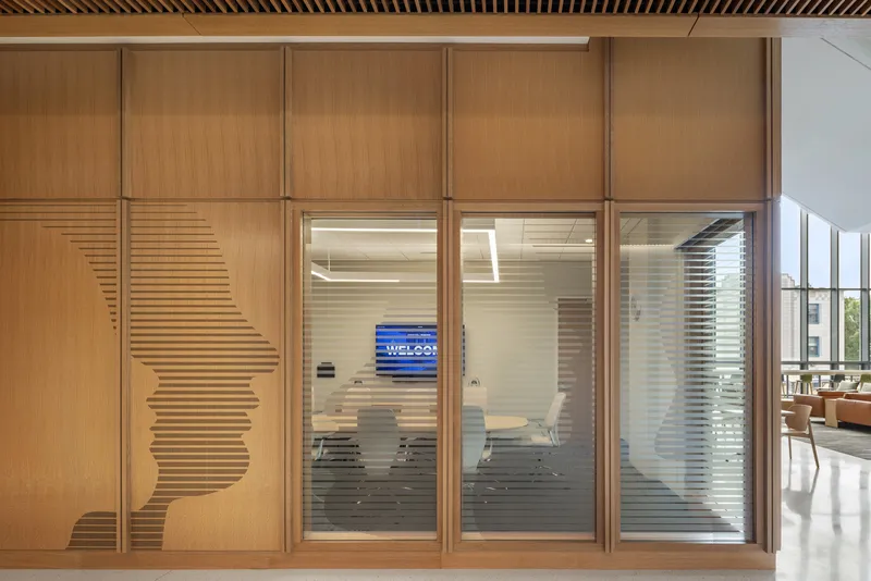 Wood-paneled wall with horizontal slatted pattern and glazed meeting room doors