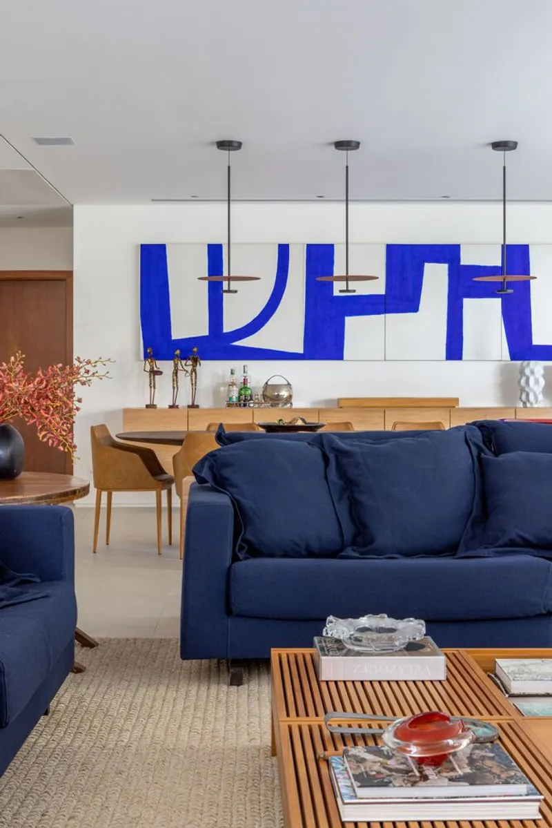 Living room with white tiled wall featuring blue graphic pattern and pendant lights overhead