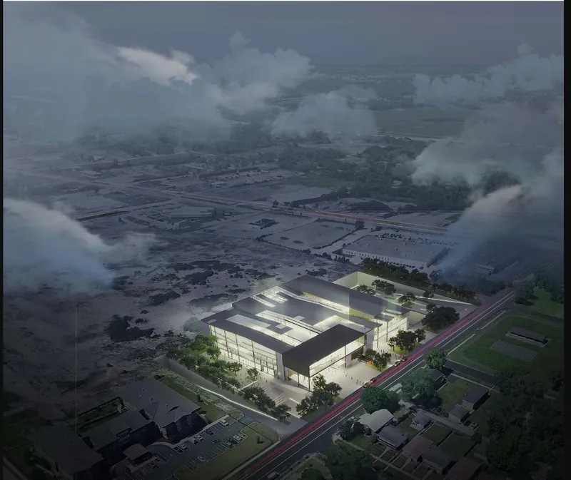 Aerial rendering of the rectangular warehouse volume with rooftop skylights under low clouds at dusk