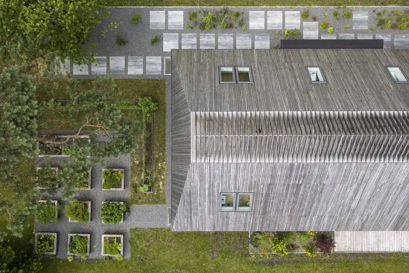 Aerial view of the weathered timber roof with skylights and adjacent paved terrace grid