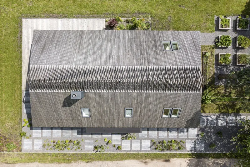 Aerial view of the corrugated metal gable roof with skylights and a rooftop terrace garden