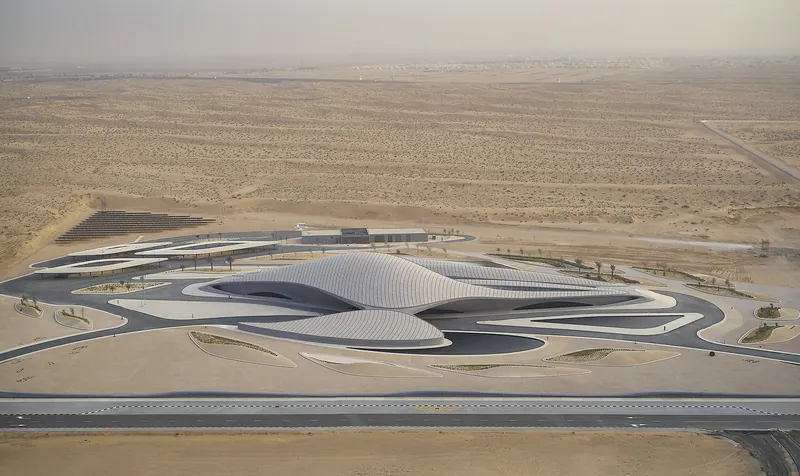 Aerial view of the undulating ribbed roof surrounded by desert terrain and access roads