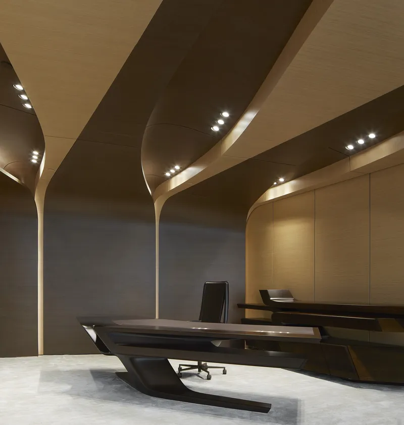 Interior office space with curved branching columns supporting a wood-paneled ceiling with recessed lighting