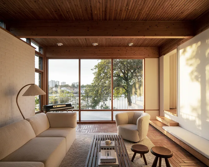 Living space with herringbone parquet flooring and timber plank ceiling in warm afternoon light