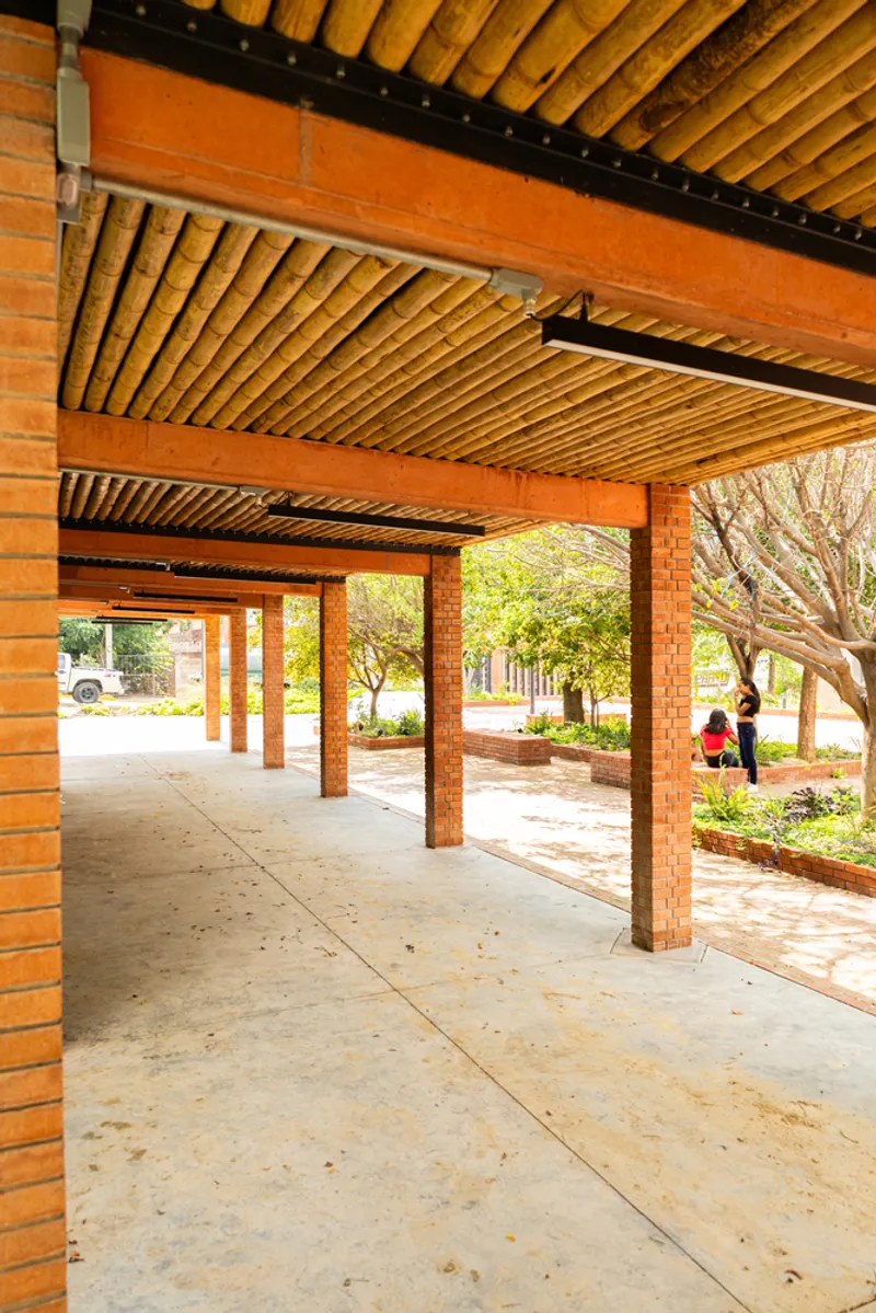 Covered walkway with brick piers supporting timber beam and slatted bamboo ceiling panels overhead