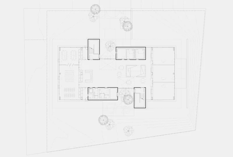 Site plan drawing showing rectangular volumes arranged around central courtyard with scattered trees