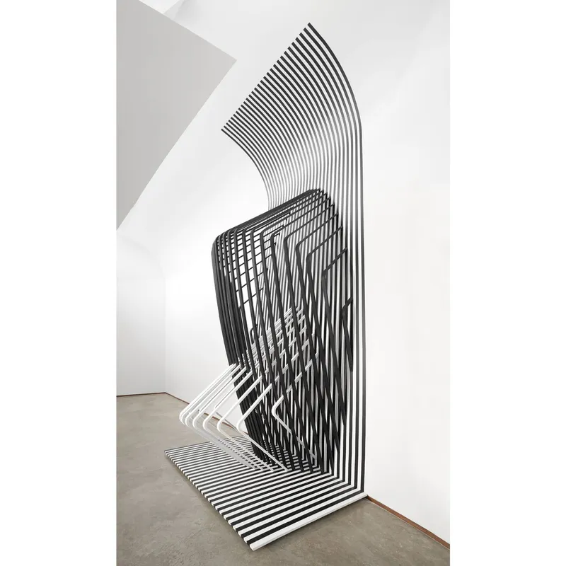 Corner installation with black and white striped tape forming a folded geometric pattern on wall and floor