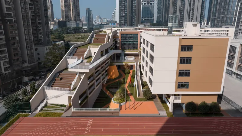 Aerial view of the rooftop terraces with planted gardens and a running track in the foreground