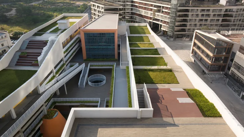 Rooftop terrace with green lawn panels and circular skylight above interior courtyard