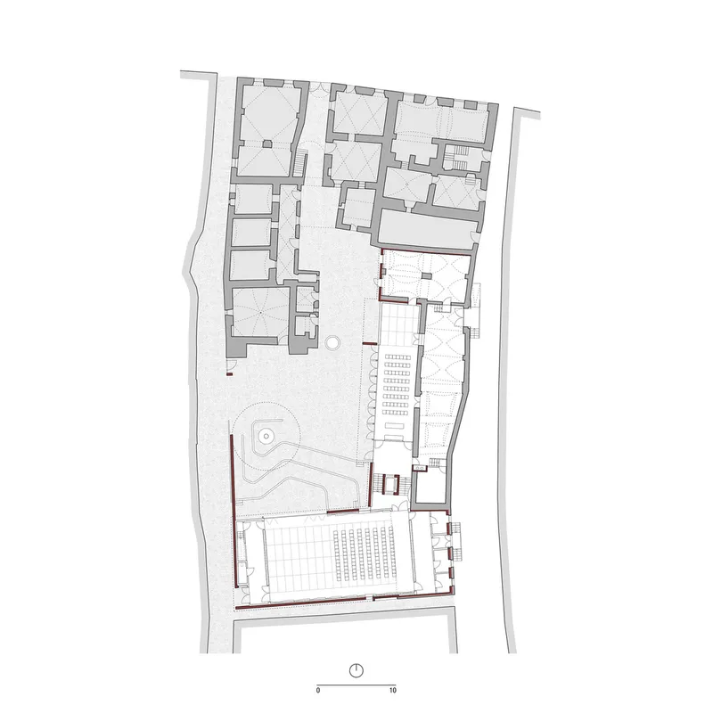 Floor plan drawing showing interior rooms and a courtyard with circular water feature and seating grid