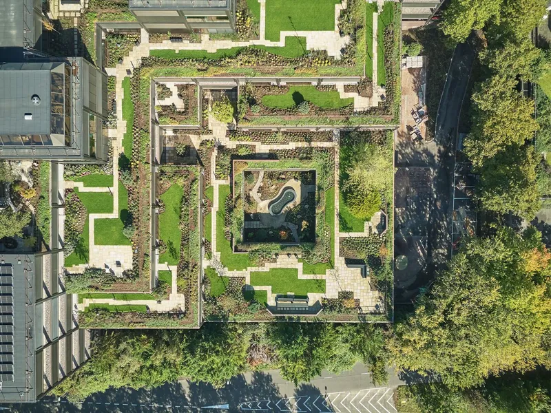 Drone view of the planted roof terraces stepping inward around a central courtyard with water feature