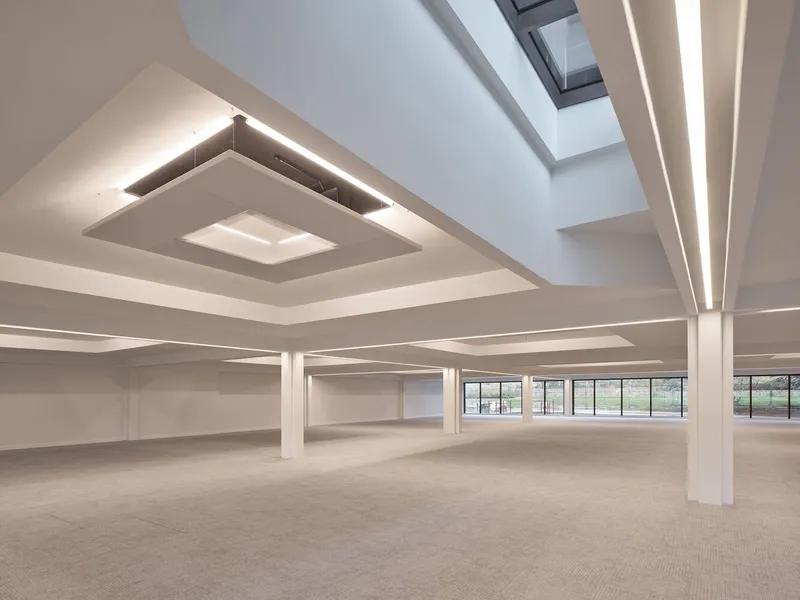 Interior space with stepped ceiling coffers, integrated linear lighting and skylights bringing natural light