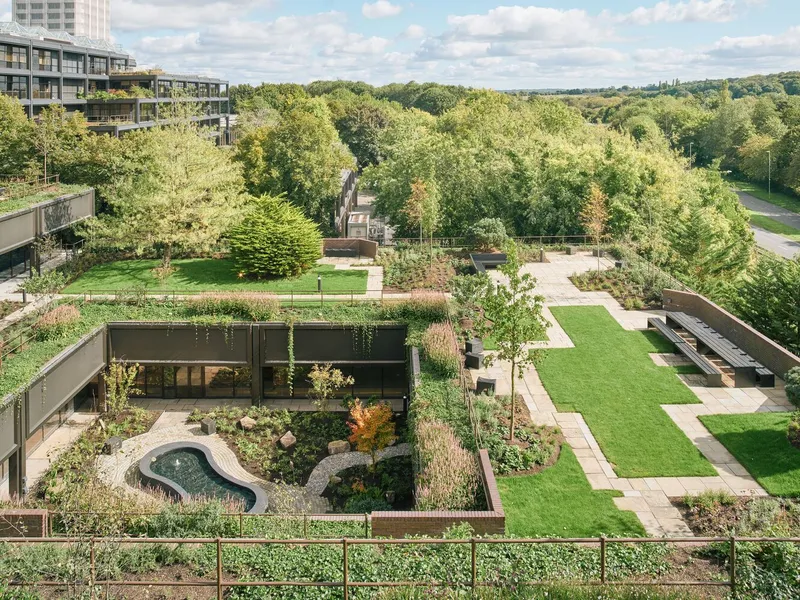 Elevated view of rooftop garden with planted beds, lawn panels and curving water feature