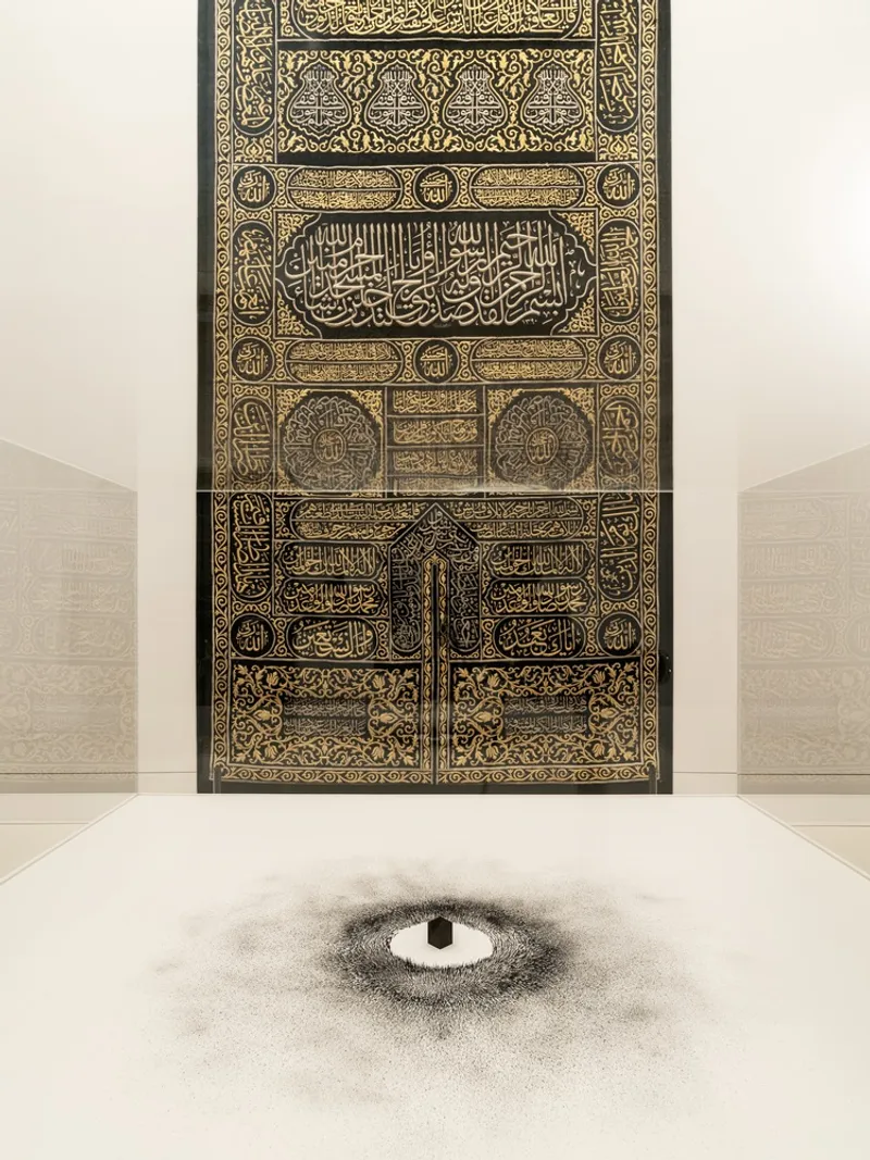 Ornate gold and black embroidered door panel centered above a circular floor pattern in pale stone