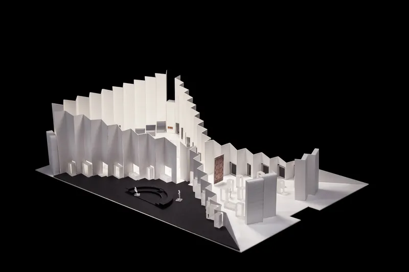 Physical model with folded vertical planes forming a volumetric composition around a central courtyard