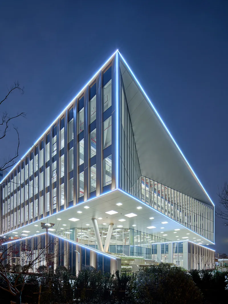 Night view of the illuminated building corner with LED edge lighting and white structural columns