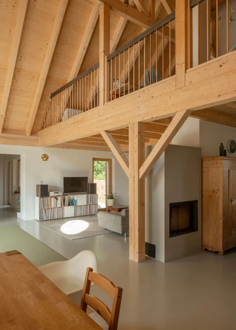 Interior view showing timber structural columns and beams supporting a mezzanine with vertical balustrade rails
