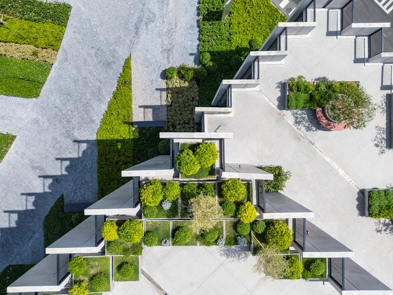 Overhead view of stepped rooftop terraces with green planters arranged in a grid pattern