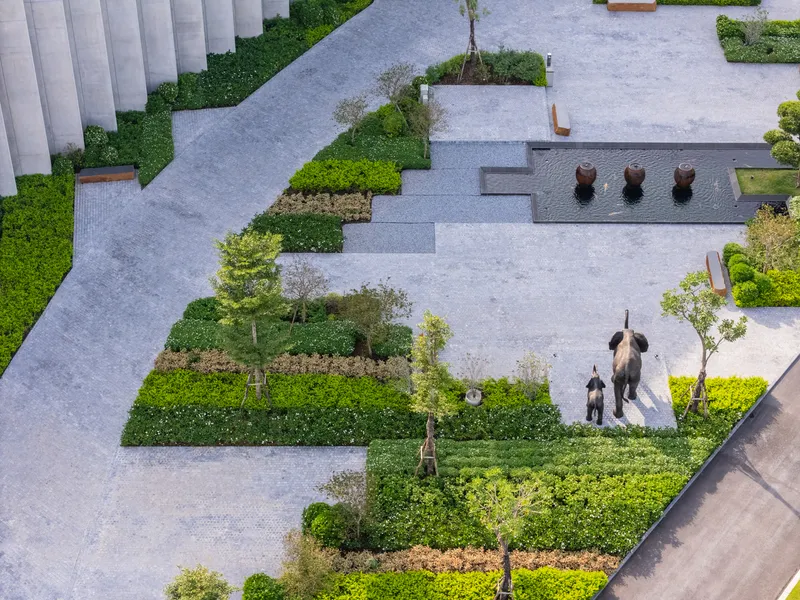 Aerial view of paved plaza with elephant sculptures among planted beds and geometric pathways