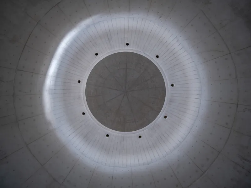 Looking up at circular oculus with concealed perimeter lighting in concrete dome