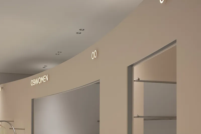 Recessed wall niche with horizontal display shelves beneath numbered department signage