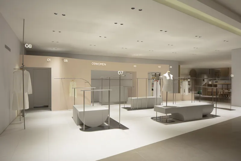 Wide view of retail floor with steel and concrete display fixtures under recessed ceiling lights