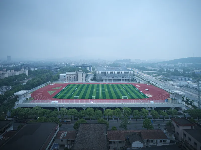 Aerial view of rooftop running track and soccer pitch in early morning haze