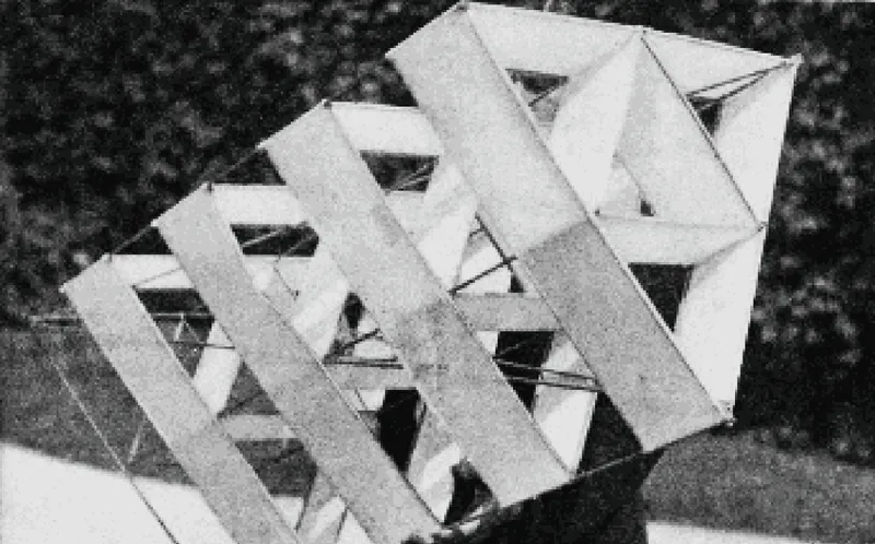 Aerial view of interlocking white geometric roof planes with triangular voids over forested terrain